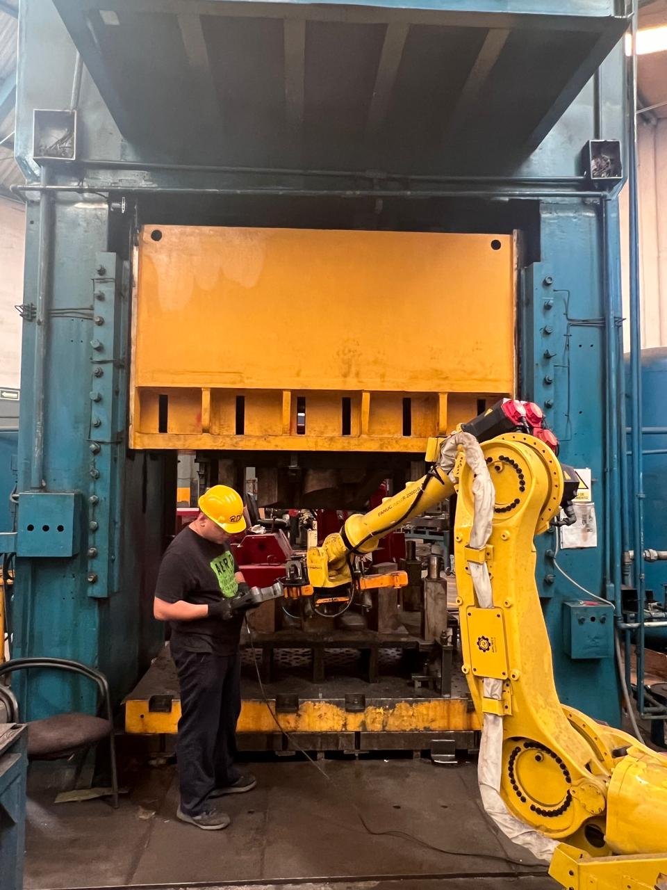 Prensa de estampado con robot FANUC y operador